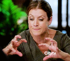 A Woman Is Making A Face With Her Hands In Front Of A Citytv Sign GIF