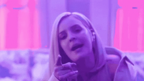 A Woman Is Making A Funny Face In Front Of A Purple Background . GIF