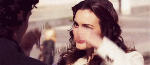 A Woman Is Making A Funny Face While A Man Holds Her Face . GIF