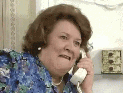 A Woman Is Making A Funny Face While Talking On A Phone . GIF