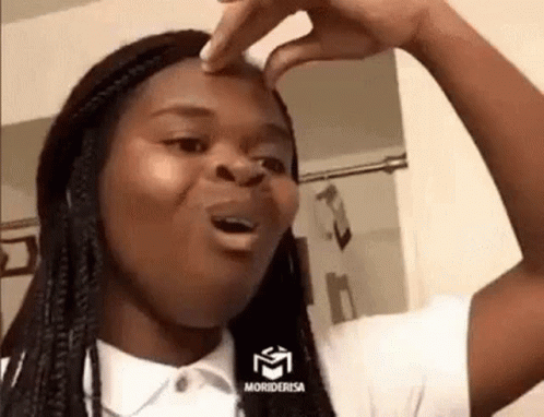 A Woman Is Making A Funny Face While Touching Her Nose . GIF