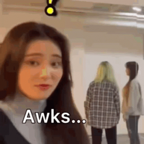 A Woman Is Making A Funny Face While Two Other Women Are Standing Behind Her . GIF