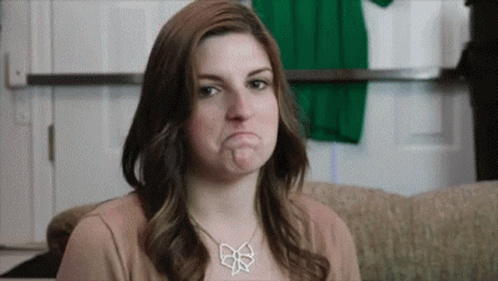 A Woman Is Making A Funny Face While Wearing A Necklace . GIF