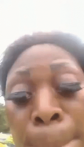 A Woman Is Making A Funny Face With Her Eyes Closed . GIF
