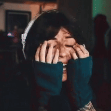 A Woman Is Making A Funny Face With Her Hands On Her Face . GIF