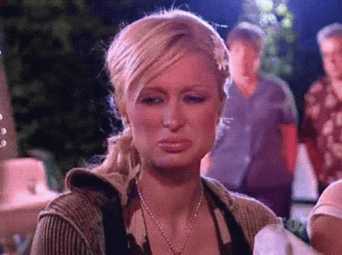 A Woman Is Making A Funny Face With Her Mouth Open While Standing In Front Of A Group Of People . GIF
