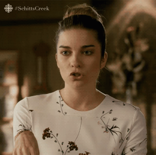 A Woman Is Making A Funny Face With #Schitts Creek Written On The Bottom GIF