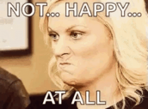 A Woman Is Making A Funny Face With The Words `` Not Happy At All '' Written On Her Face . GIF
