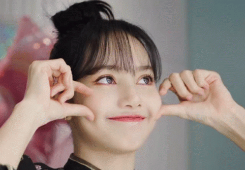 A Woman Is Making A Heart Shape With Her Hands GIF