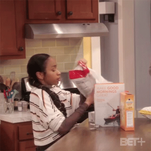 A Woman Is Opening A Box Of Make Good Mornings Cereal GIF