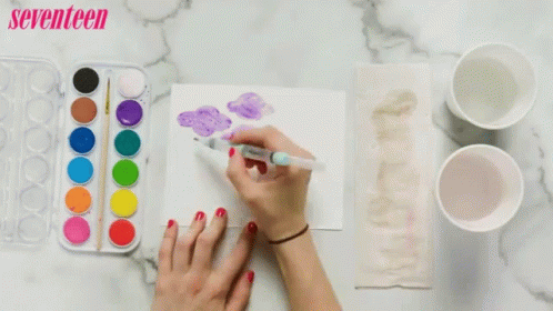A Woman Is Painting A Picture With Watercolors And A Seventeen Logo In The Background GIF