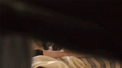 A Woman Is Peeking Out From Behind A Man 'S Shoulder . GIF