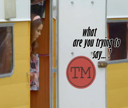 A Woman Is Peeking Out Of A Yellow Trailer With A Tm Sticker On The Door GIF