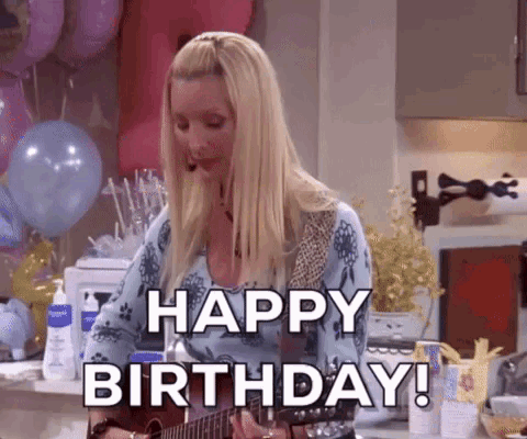 A Woman Is Playing A Guitar In A Kitchen And Says Happy Birthday . GIF