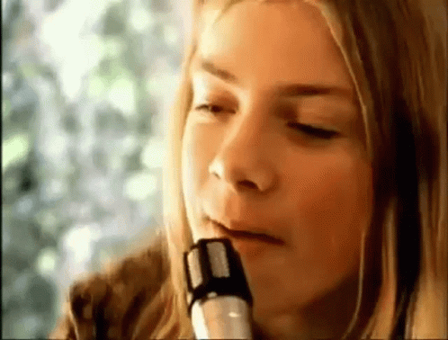 a woman is playing a saxophone with her eyes closed .