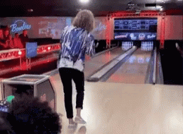 A Woman Is Playing Bowling In A Bowling Alley With A Sign That Says Bowlline GIF