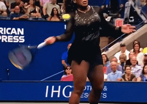 A Woman Is Playing Tennis In Front Of A Banner That Says Ihg GIF