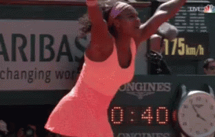 A Woman Is Playing Tennis In Front Of A Sign That Says ' Aribas Changing Work ' GIF