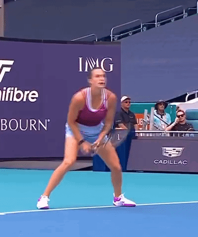a woman is playing tennis in front of a sign that says img on it