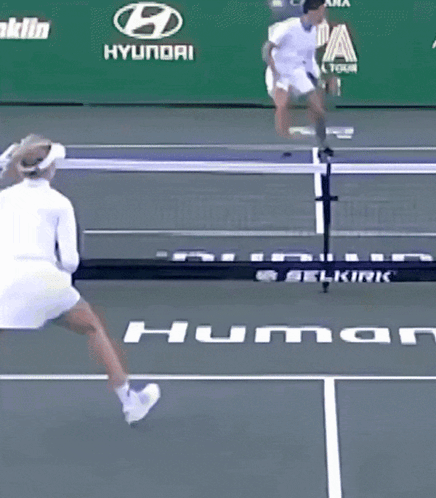 A Woman Is Playing Tennis On A Court With An Ad For Franklin Hyundai Behind Her GIF