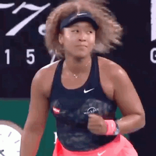 A Woman Is Playing Tennis On A Tennis Court . GIF