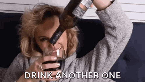 A Woman Is Pouring A Bottle Of Wine Into A Glass While Sitting On A Couch . GIF