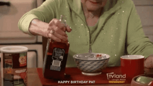 A Woman Is Pouring Ketchup Into A Bowl While Sitting At A Table . GIF