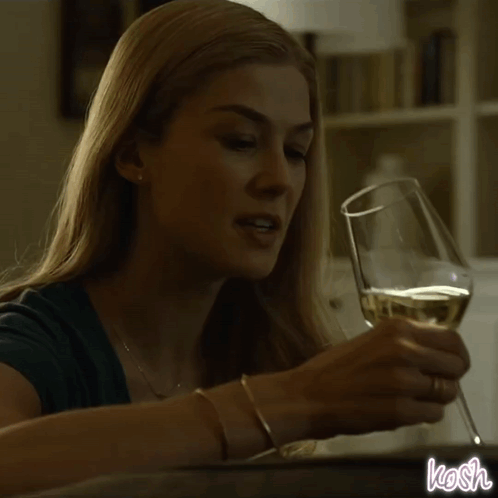 A Woman Is Pouring Wine Into A Glass And The Word Kosh Is On The Bottom GIF