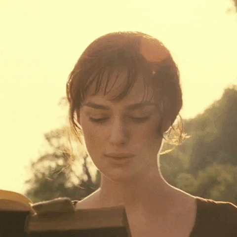 A Woman Is Reading A Book With Her Eyes Closed . GIF