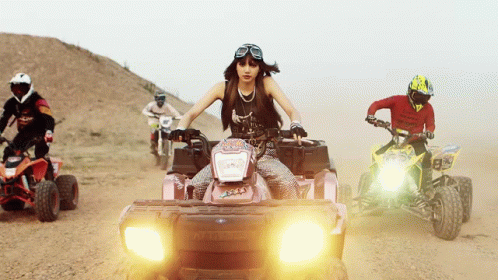 a woman is riding a pink polaris atv in the desert