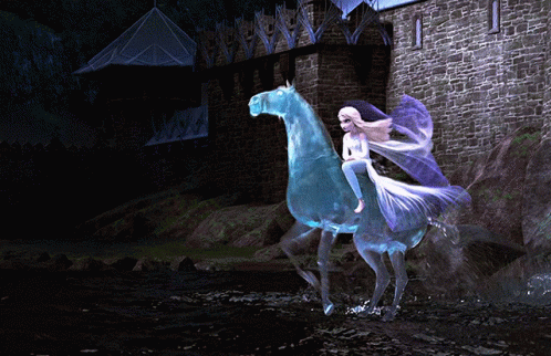 A Woman Is Riding On The Back Of A Blue Horse In Front Of A Castle GIF