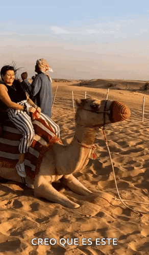 A Woman Is Riding On The Back Of A Camel In The Desert With The Caption Creo Que Es Este GIF