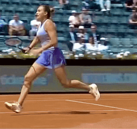 a woman is running on a tennis court holding a racket