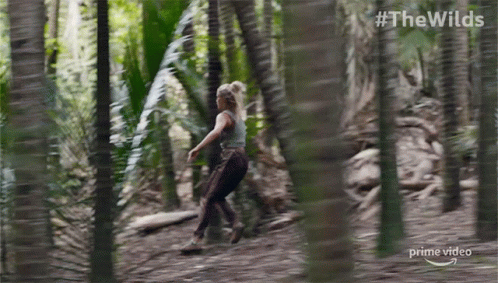 A Woman Is Running Through A Forest In A Prime Video Ad GIF