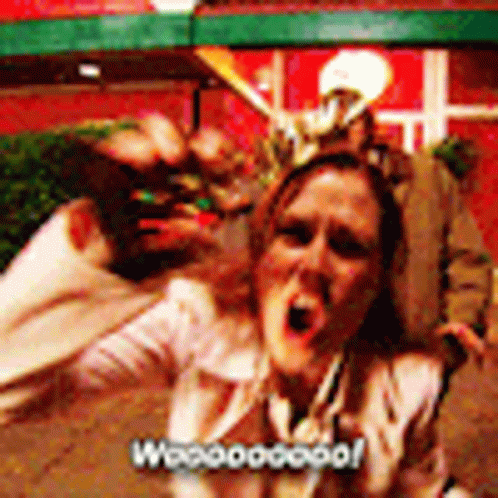 A Woman Is Screaming In Front Of A Group Of People And The Words Woooogood Are On The Bottom Right GIF