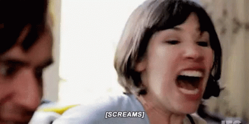 A Woman Is Screaming In Front Of A Man While Sitting Next To Him . GIF