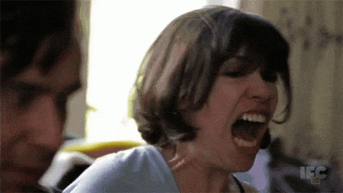 A Woman Is Screaming In Front Of A Man With The Letters Ifc On The Bottom Right GIF