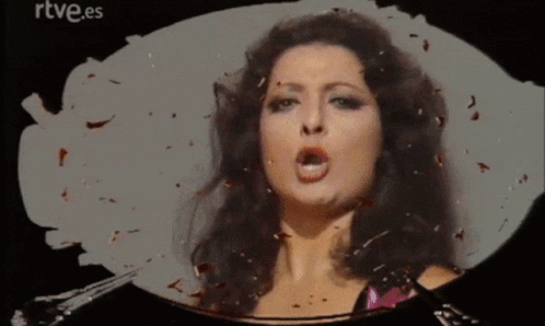 a woman is singing in front of a rtve.es logo