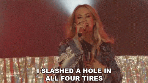 A Woman Is Singing Into A Microphone And Saying `` I Slashed A Hole In All Four Tires '' GIF