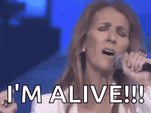 A Woman Is Singing Into A Microphone And Says I 'M Alive ! GIF