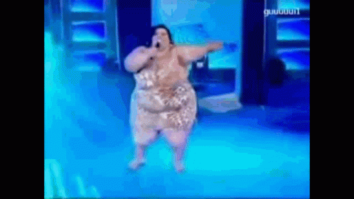 A Woman Is Singing Into A Microphone While Dancing On A Stage . GIF