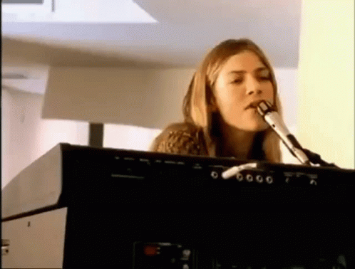 a woman is singing into a microphone while playing an electronic keyboard .