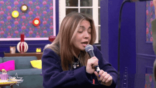 Woman Singing Into Microphone In Purple Sweater GIF