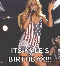 A Woman Is Singing Into A Microphone While Wearing An American Flag Outfit . GIF