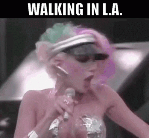 A Woman Is Singing Into A Microphone With Her Mouth Open . GIF