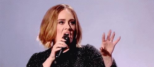 A Woman Is Singing Into A Microphone With Her Mouth Open . GIF