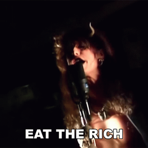 A Woman Is Singing Into A Microphone With The Words Eat The Rich Written Below Her GIF