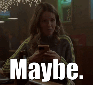 A Woman Is Sitting At A Bar Looking At Her Phone And The Word Maybe Is Visible GIF