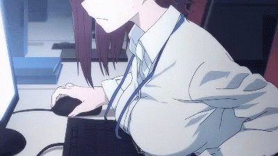 A Woman Is Sitting At A Desk Using A Computer And Mouse GIF