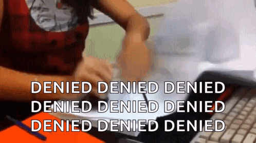 A Woman Is Sitting At A Desk Using A Laptop Computer With The Words Denied Denied Denied Denied Denied Denied Denied GIF